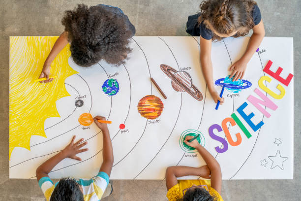istock Kids colouring a picture of outer space 1220202217