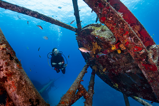 View of the Kittiwake Shipwreck and a female diver in Grand Cayman - Cayman Islands