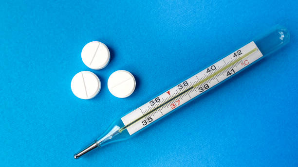 istock thermometer with temperature and antipyretic pills on a blue background 1220206037