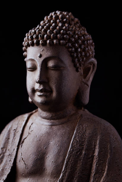 istock Meditating Buddha Statue isolated on black background. 1220206109