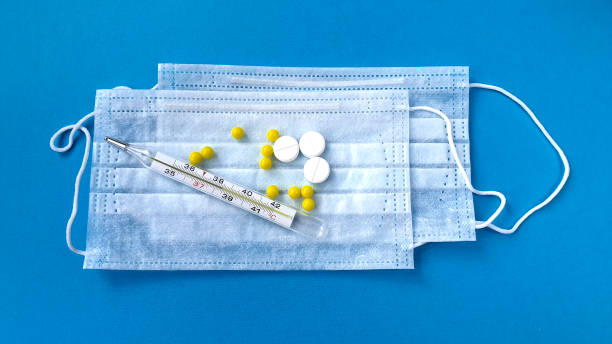 istock Thermometer with temperature, tablets and disposable mask 1220206116