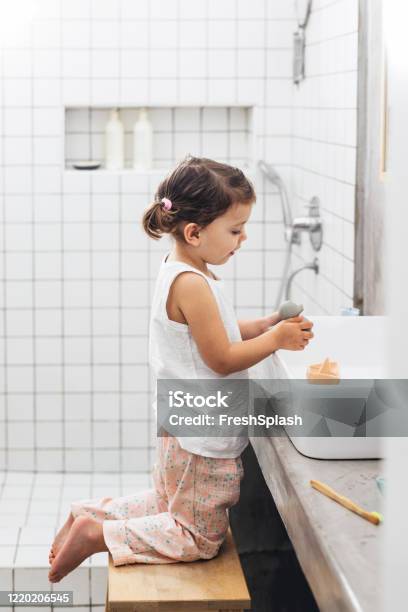 Happy Girl In Pajamas Playing With Rubber Toys In The Bathroom Sink Stock Photo - Download Image Now