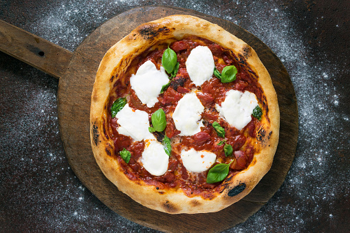 Pizza, made with tomato, mozzarella, basil and olive oil.