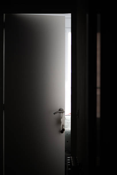 istock Silver handle with decoration on a white door with light coming from the bedroom 1220211242