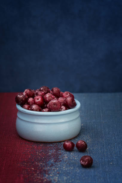 Cherry in a blue bowl on a blue background stock photo
