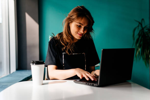 istock Beautiful young college student working in a cafe on a laptop 1220212983