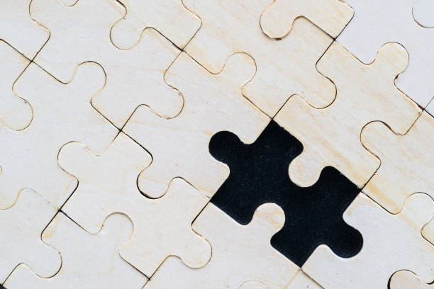 istock Close up wooden jigsaw puzzle pieces on black background 1220213156