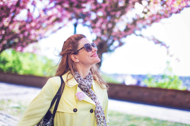 istock Young woman enjoying springtime Sakura 1220214155
