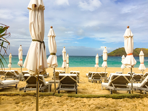 Cloudy day at St. Barth's with closed umbrellas and loungers.