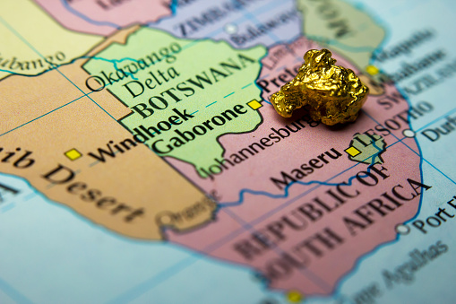 Close-up of a gold nugget on top of a map of Peru