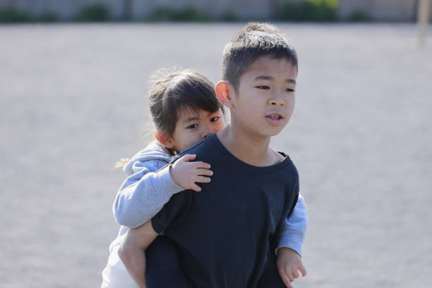 istock Japanese boy carrying his sister in his back (10 years old boy and 5 years old girl) 1220216956