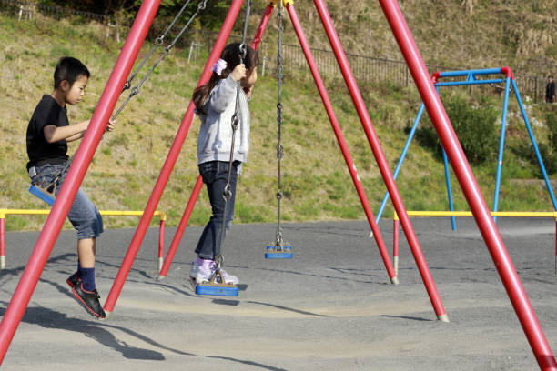Japanese brother and sister on the swing  (10 years old boy and 5 years old girl)