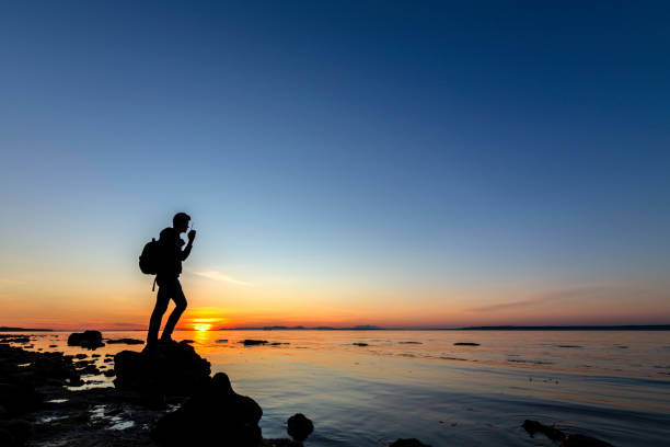 istock Man with walkie-talkie on rock of seaside 1220218143