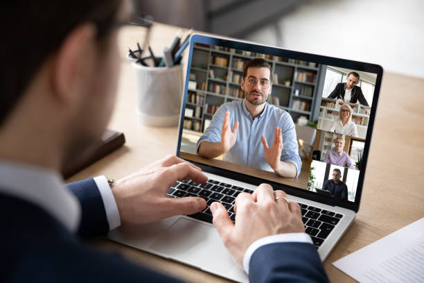 View over businessman shoulder laptop screen and videocall diverse participants Businessman boss leader leads distant communication diverse businesspeople involved in group videocall conversation discuss common project, partners negotiating. Modern technology and business concept webcam view man stock pictures, royalty-free photos & images