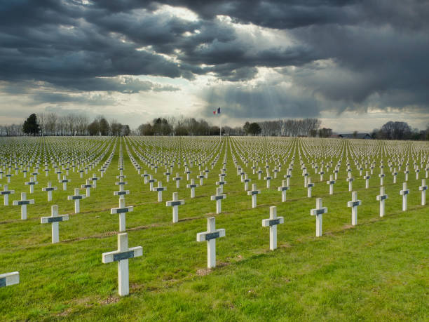 Rows of WW1 graves in La Targette cemetery in Northern France. Against dark, threatening skies, rows of graves of WW1 soldiers marked by white crosses in La Targette cemetery near Arras in Northern France. The French flag flies in the breeze. french flag stock pictures, royalty-free photos & images