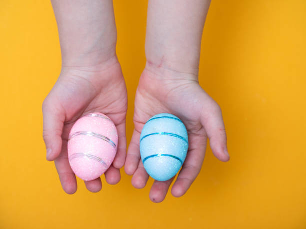 istock baby hand close up holding Easter eggs and chicks 1220220902
