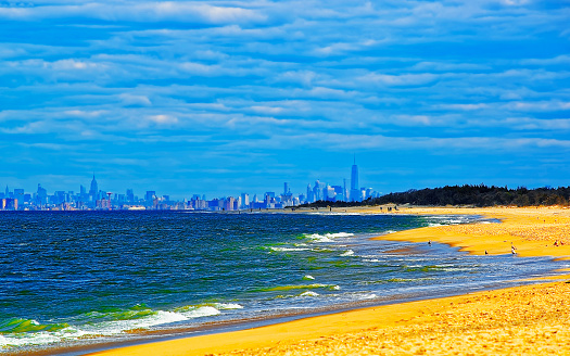 Scenery on Atlantic Ocean Bay shore at Sandy Hook. View on NYC from lighthouse, or light house. It is called Navesink Twin Lights. It is in Highlands in Monmouth County in New Jersey, USA. Blue sky