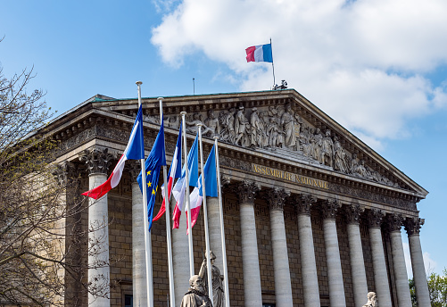 Paris, France: French and European Union flags in the wind in front of National Assembly