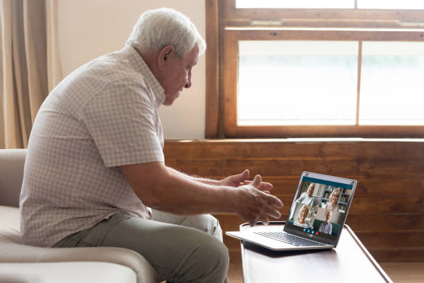 dziadek rozmawia z przyjaciółmi za pomocą kamery komputerowej i aplikacji wideokonferencji - senior adult grandfather 70s discussion zdjęcia i obrazy z banku zdjęć