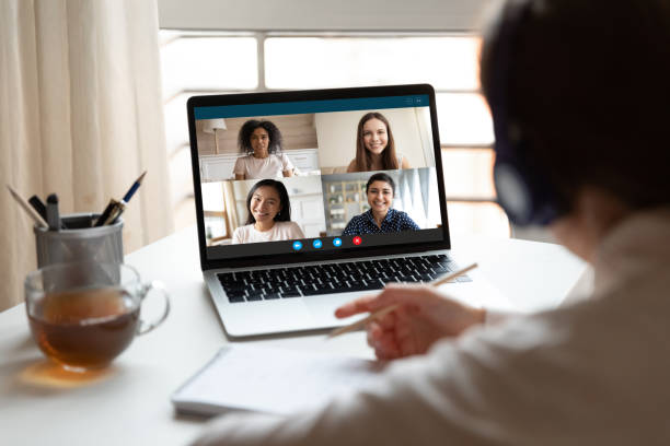 Woman studying at home with multiracial students via video conference
