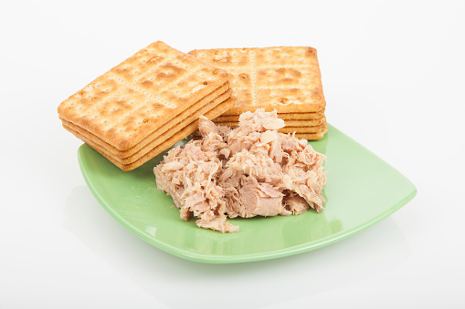 Cookies of salt with canned tuna; photo on white background.