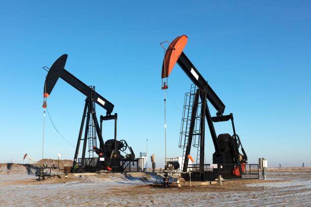 North American  Oil Pump jacks, producing oil.  2 in a row working away, morning image taken from a tripod. oil pump petroleum equipment development stock pictures, royalty-free photos & images