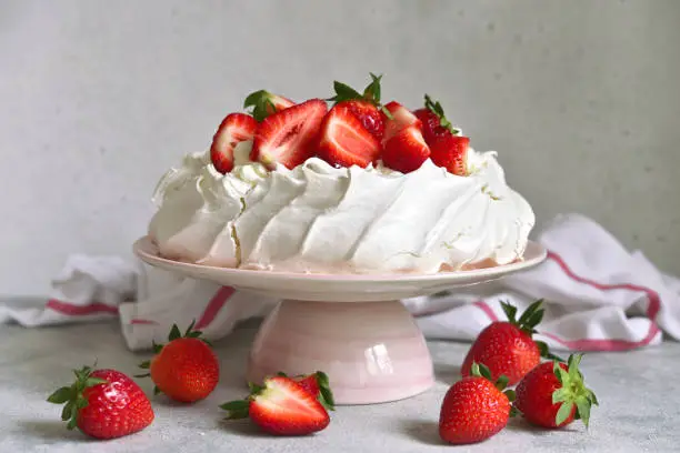 Homemade delicious meringue cake "Pavlova" with fresh straberry and mascarpone on a white background.