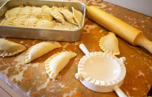 Preparation of mini pies (empanada) with rolling pin and flour around
