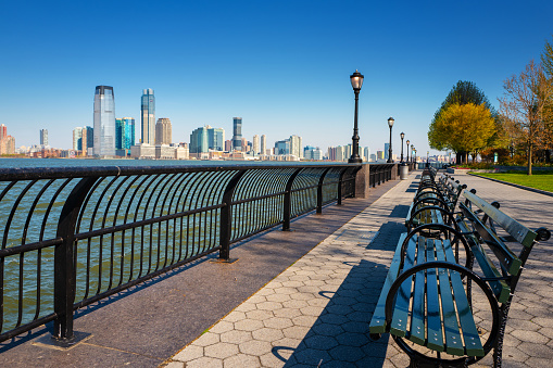 Manhattan, New York, USA - April 19,2020: No people on the Battery park esplanade during the coronavirus pandemic on a warm spring day. View of Jersey city on the other side of the Hudson river.