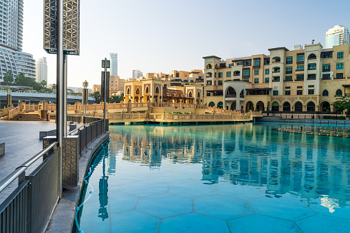 Dubai center in morning sunrise, pool of dancing fountains near Dubai Mall, UAE.