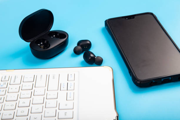 istock White keyboard, Smartphone with Wireless bluetooth headphones isolated on blue background 1220237114