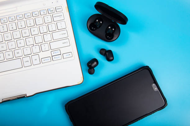istock White keyboard, Smartphone with Wireless bluetooth headphones isolated on blue background 1220237117