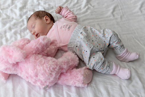 Baby girl sleeping with her plush toy