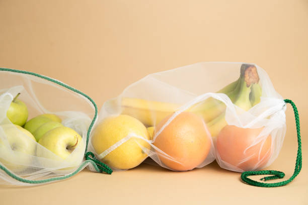 istock Two meshed bags, zero waste concept. Eco-friendly zero waste fruit bag. Apple, bananas, grapefruits and lemon inside. 1220240648