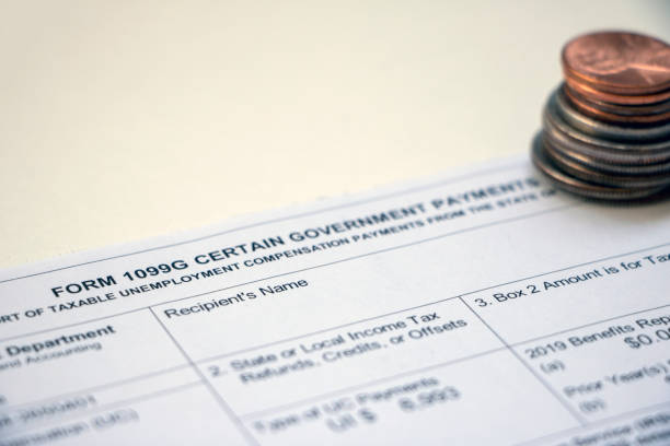 Form 1099G with coins Closeup of the top of a tax Form 1099G Certain Government Payments - Taxable Unemployment Compensation Payments with stack of coins. insufficient funds stock pictures, royalty-free photos & images