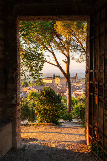 vista al tramonto attraverso la porta a san gimignano - san gimignano immagine foto e immagini stock