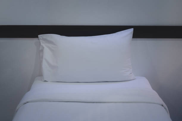istock White bedding and pillow in hotel room. Comfort and bedding concept 1220254067