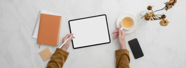 istock Top view of college student doing homework with mock-up tablet on marble desk 1220256459