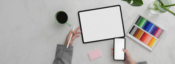 istock Overhead shot of designer working on mock-up smartphone and tablet on marble table 1220256523