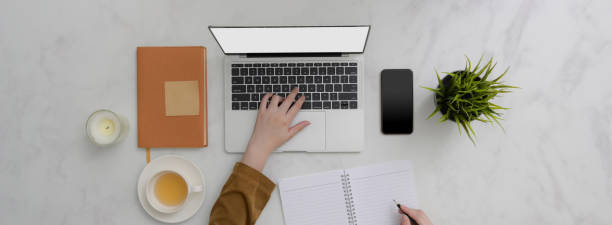 istock Overhead shot of college student doing assignment with laptop on marble table 1220256707