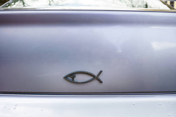 Christian Religious Fish Symbol on Vehicle Rear - Back of silver car with symbol displayed.