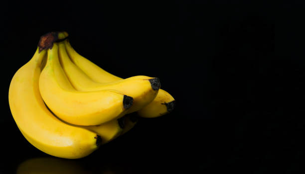 istock A bunch of bananas isolated on a black background. Copy space. 1220258386