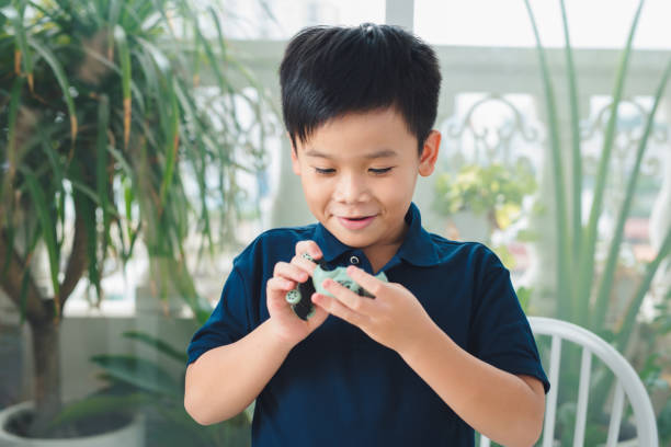 istock School boy playing with toy car on a table at home. 1220258561
