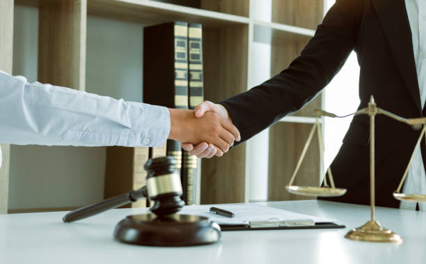 istock Lawyer is currently shaking hands with the client about the success in resolving the case. 1220263316