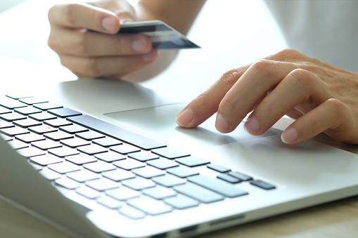 Manos de mujer sostienen tarjetas de crédito y utilizar el teclado de la computadora Notebook .online concepto de compras photo