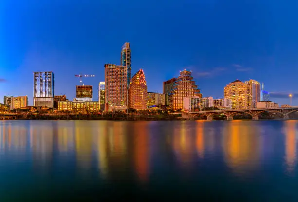 Photo of Downtown view across Lady Bird Lake or Town Lake on Colorado River at sunset golden hour in Austin, Texas, USA