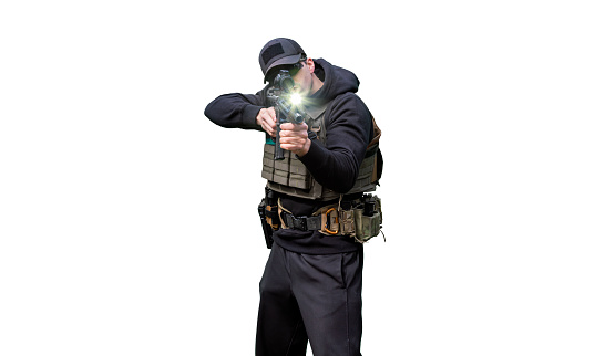 Army Man wearing Tactical Uniform and holding Machine Gun in Hands and Aiming. Isolated on White Background. Black Clothes and Hoody