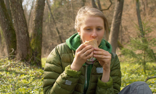 istock Nice woman eating sanwich in forest 1220267561