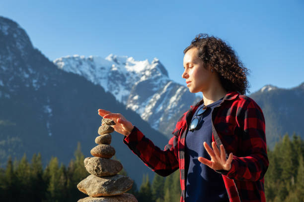 Girl in Canadian Nature Girl with Balancing Rocks on the beach by the Alouette Lake during a sunny winter day. Taken in Golden Ears Provincial Park, near Vancouver, British Columbia, Canada. alouette lake stock pictures, royalty-free photos & images
