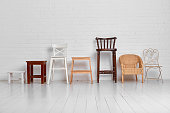 There are many different chairs in the white room. The concept of unity of different